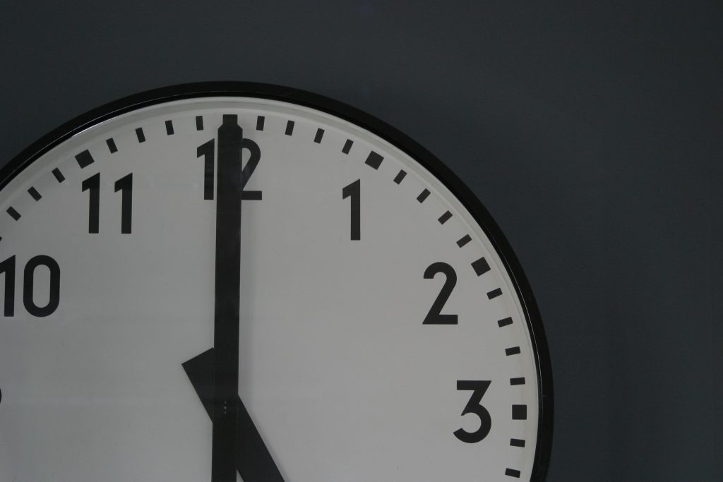 analog clock showing hour hand at twelve 