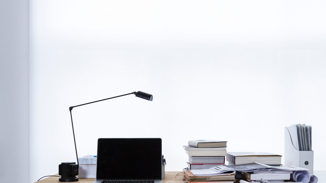 laptop on desk with books